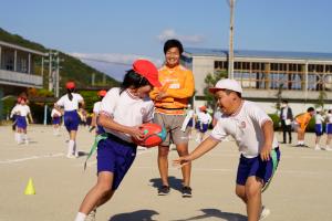 タグラグビーを楽しむ生徒と見守る選手