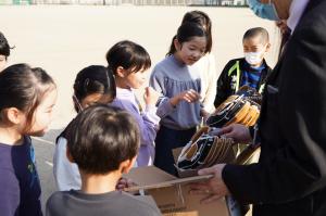 グローブを見て喜んでいる子供たちの写真