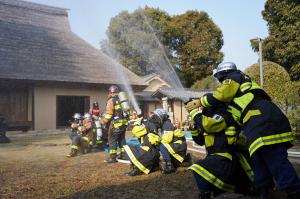 上に向かって放水する消防団員達の写真