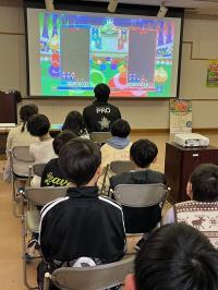 プロの対戦を見守る子供たちの写真