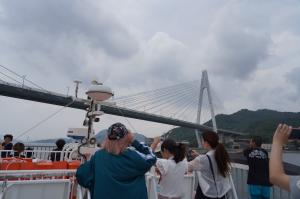 船のデッキから端を見る参加者の写真